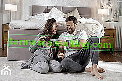 Mann und Frau betrachten Fotos im Schlafzimmer