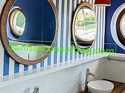 бели и сини ивици на стената на банята, кръгло огледало в дървена рамка, дървен плот за баня
